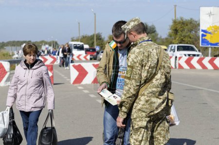 Foto de Guardia fronteriza que revisa el pasaporte del viajero en el paso fronterizo Kalanchak, frontera terrestre ucraniano-rusa. 20 de septiembre de 2017. Región de Kalanchak, Provincia de Khersonskaya, Ucrania - Imagen libre de derechos