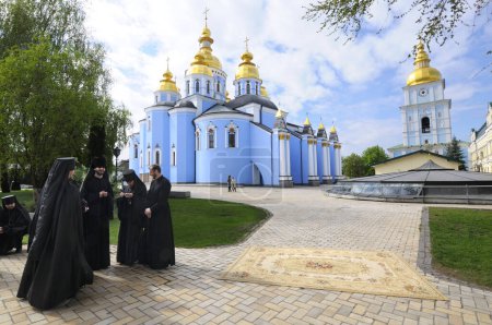 Téléchargez les photos : Groupe de moines debout près de l'église, St. Michael Golden-dôme monastère sur un fond. 27 avril 2018. Kiev, Ukraine - en image libre de droit