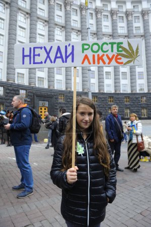 Photo for Group of young people activists standing near Cabinet of Ministry holding broadsheet demanding legalization of medical marijuana. Cannabis March. October 26, 2019. Kyiv, Ukraine - Royalty Free Image