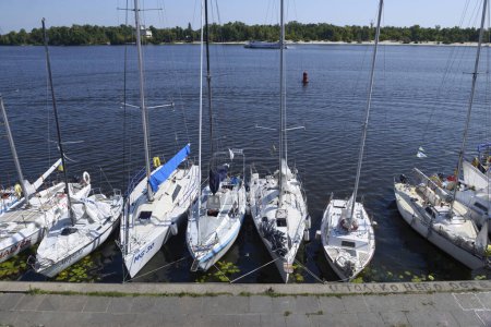 Téléchargez les photos : Yachts à voile amarrés à la jetée du port fluvial. Kiev, Ukraine - en image libre de droit