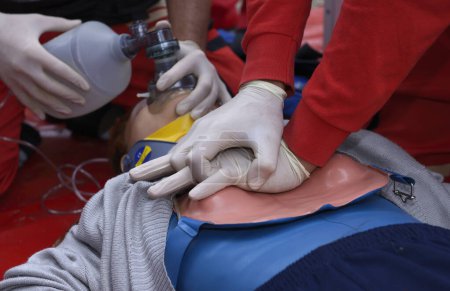 Téléchargez les photos : Un secouriste appuie sur la poitrine d'un patient, gardant un coussin d'oxygène sur son visage. Respiration artificielle - en image libre de droit