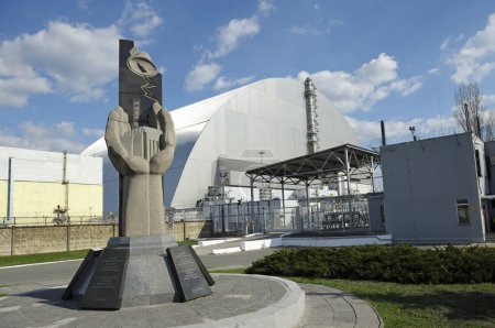 Denkmal für die Liquidatoren von Tschernobyl, Neue sichere Einsperrung des Kernkraftwerks auf einem Hintergrund. Tschornobyl, Ukraine