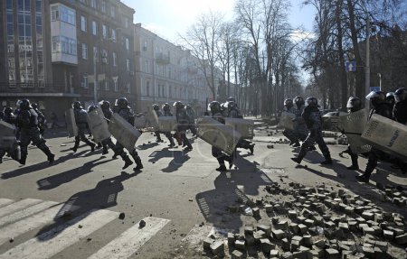 Photo for Policemen (Berkut unit) attacking protesters on Institutskaya street. Revolution of Dignity, the first street clashes. February 18, 2014. Kiev, Ukraine - Royalty Free Image