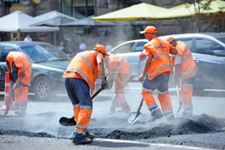 Téléchargez les photos : Travailleurs asphalte réparer la route sur la rue de la ville. 7 août 2021. Kiev, Ukraine - en image libre de droit