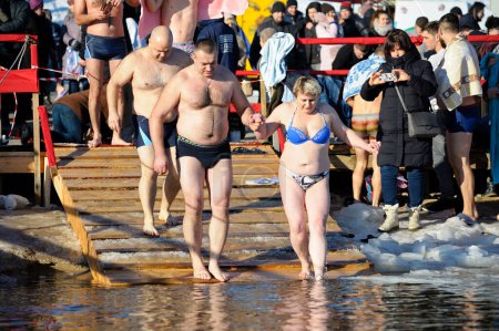 Téléchargez les photos : Baptême. Les gens en maillots de bain vont au trou glacé avant de plonger dans l'eau froide pendant le festin Epiphanie sur la rivière, les gens en maillots de bain sur un fond. 19 janvier 2019. Kiev, Ukraine - en image libre de droit