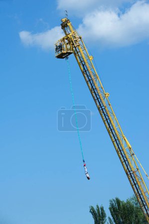 Photo for Bungee jumping. Young woman jumping from the high rise tower crane. Hydropark, Kyiv, Ukraine - Royalty Free Image