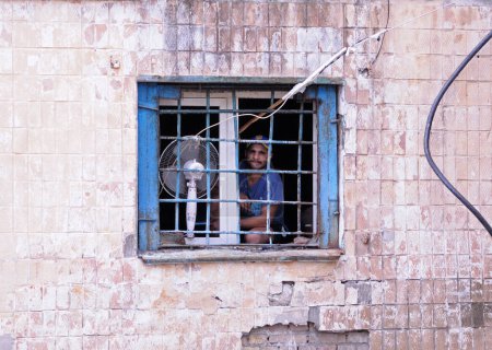 Téléchargez les photos : Prisonnier regardant par les barreaux de la prison sur la fenêtre. Centre de détention de Lukyanovskaya. 18 juillet 2017. Kiev,Ukraine - en image libre de droit