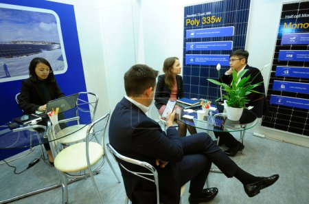 Foto de Empresarios descansando en la mesa de la sala de negociaciones durante una exposición. Feria de Energía Solar. 19 de abril de 2019.Kiev, Ucrania - Imagen libre de derechos