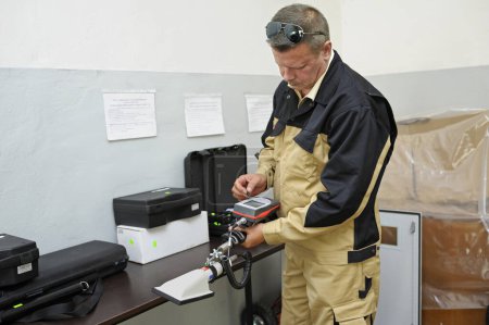 Foto de Nueva prueba de detector de radiación. Dosimetrista sosteniendo un dosímetro portátil de radiación gamma en un accesorio largo (sonda). 1 de octubre de 2018. Corporación estatal Radon. Kiev, Ucrania - Imagen libre de derechos