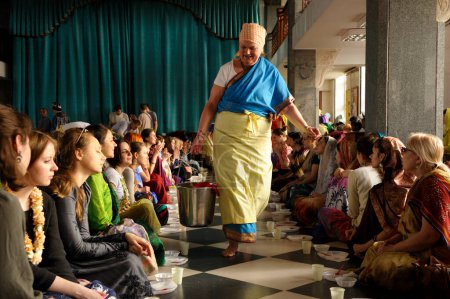 Foto de Trabajador del templo de Krishna dando a sus seguidores Prasad - alimento que es una ofrenda religiosa en el Krishnaísmo. 3 de abril de 2017. El templo de Krishna, Kiyv, Ucrania - Imagen libre de derechos