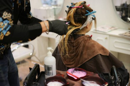 Téléchargez les photos : Male hairdresser applying drug to woman's hair - en image libre de droit