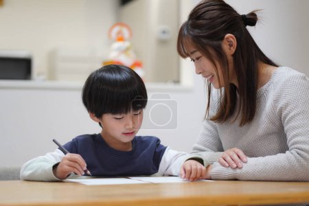 Photo for Parents and children practicing calligraphy - Royalty Free Image