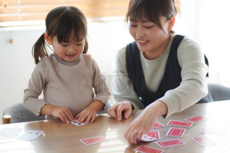 Foto de Padres e hijos jugando a las cartas - Imagen libre de derechos