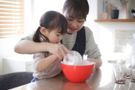 Photo for Parent and child making pudding by hand - Royalty Free Image