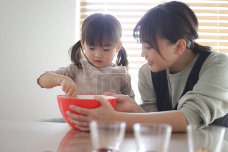 Photo for Parent and child making pudding by hand - Royalty Free Image