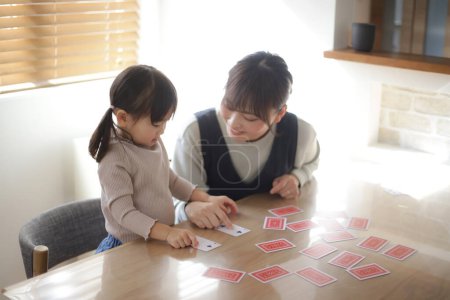 Foto de Padres e hijos jugando a las cartas - Imagen libre de derechos
