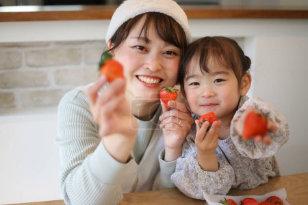 Téléchargez les photos : Parent et enfant aux fraises - en image libre de droit