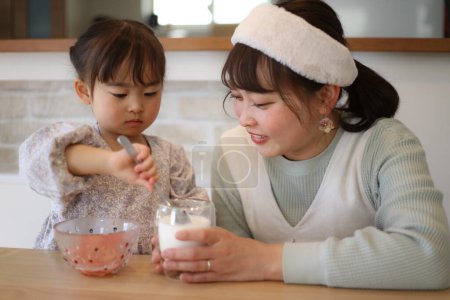 Téléchargez les photos : Parent et enfant faisant du lait de fraise - en image libre de droit