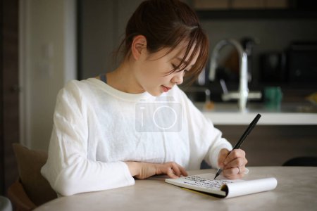 Téléchargez les photos : Une femme écrit avec un stylo pinceau - en image libre de droit