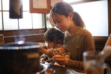 Foto de Padres e hijos comiendo en un restaurante Yakiniku - Imagen libre de derechos