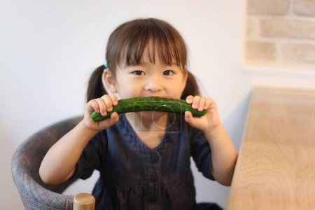 Photo for Image of a girl eating cucumbers - Royalty Free Image
