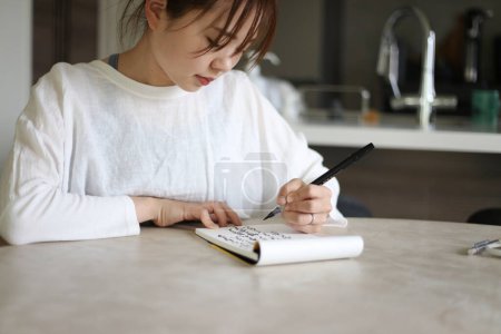 Téléchargez les photos : Une femme écrit avec un stylo pinceau - en image libre de droit