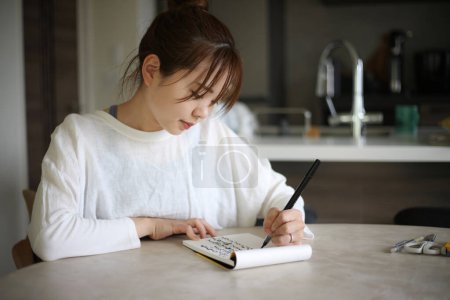 Foto de Una mujer escribiendo con una pluma de pincel - Imagen libre de derechos