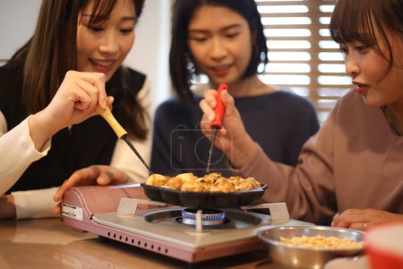 Téléchargez les photos : Une femme qui fait du takoyaki - en image libre de droit