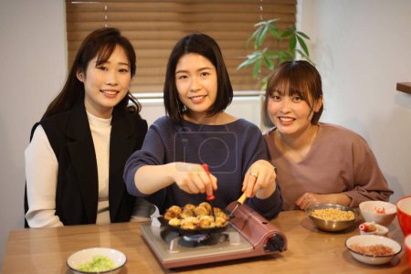 Téléchargez les photos : Une femme qui fait du takoyaki - en image libre de droit