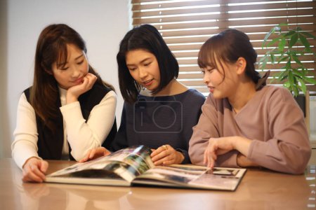 Photo for A woman looking at a graduation album - Royalty Free Image