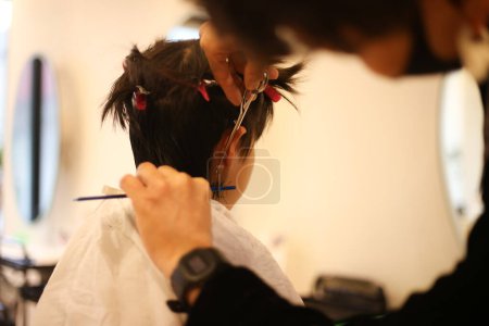 Téléchargez les photos : Homme coiffeur coupe les cheveux du garçon - en image libre de droit