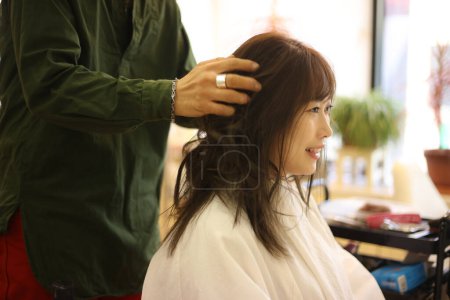 Photo for A woman getting her hair done at a beauty salon - Royalty Free Image