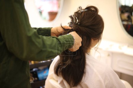 Téléchargez les photos : Une femme se fait coiffer dans un salon de beauté - en image libre de droit