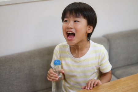 Téléchargez les photos : Image d'un garçon buvant une ramune - en image libre de droit