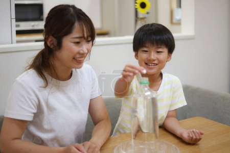 Téléchargez les photos : Parent et enfant expérimentant avec des boissons gazeuses - en image libre de droit
