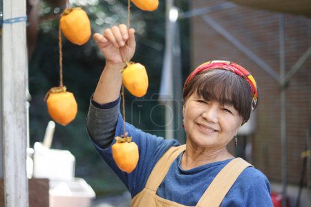 Photo for A woman drying persimmons - Royalty Free Image