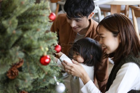 Photo for Parent and child assembling a Christmas tree - Royalty Free Image