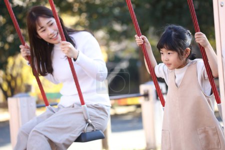 Parent and child playing on a swing