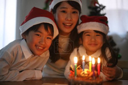 Eltern und Kind blasen eine Kerze aus