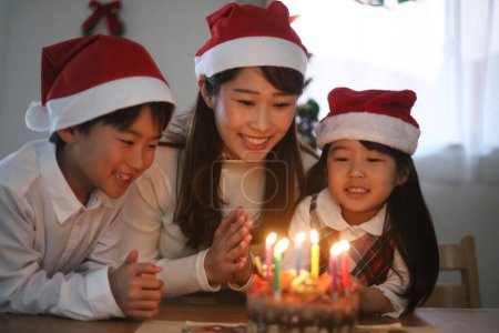 Eltern und Kind blasen eine Kerze aus