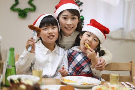 Foto de Padres e hijos comiendo imagen navideña - Imagen libre de derechos