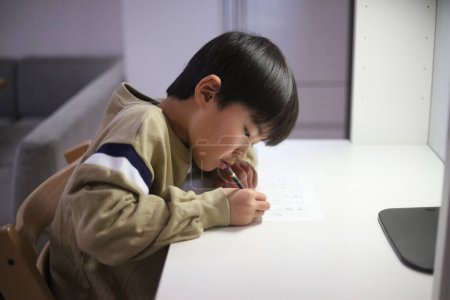 Foto de Un chico practicando caligrafía - Imagen libre de derechos