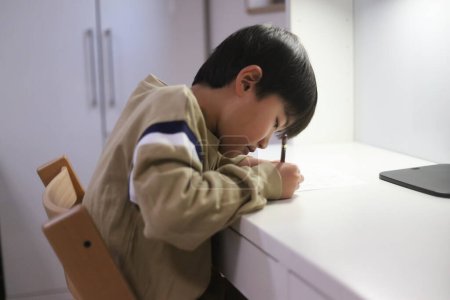 Téléchargez les photos : Un garçon pratiquant la calligraphie - en image libre de droit