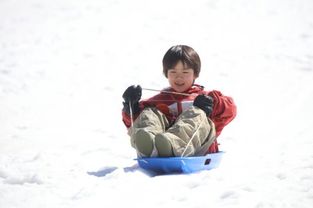 Foto de Niño jugando en un trineo - Imagen libre de derechos