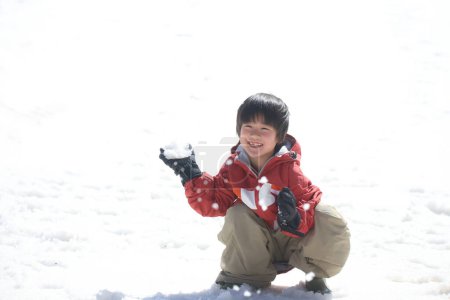 Téléchargez les photos : Garçon jouant dans la neige - en image libre de droit