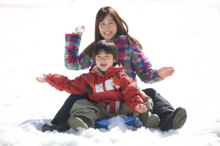 Téléchargez les photos : Parent et enfant jouent dans la neige - en image libre de droit