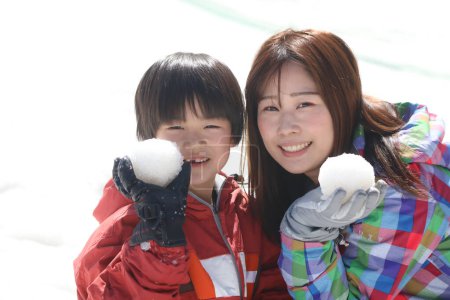 Téléchargez les photos : Parent et enfant jouent dans la neige - en image libre de droit