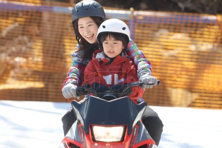 Photo for Parent and child riding a snowmobile - Royalty Free Image
