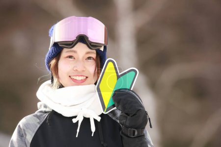 A woman in snowboarding wear with a beginner mark