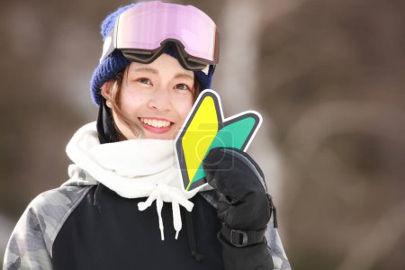 Téléchargez les photos : Une femme en tenue de snowboard avec une marque de débutant - en image libre de droit